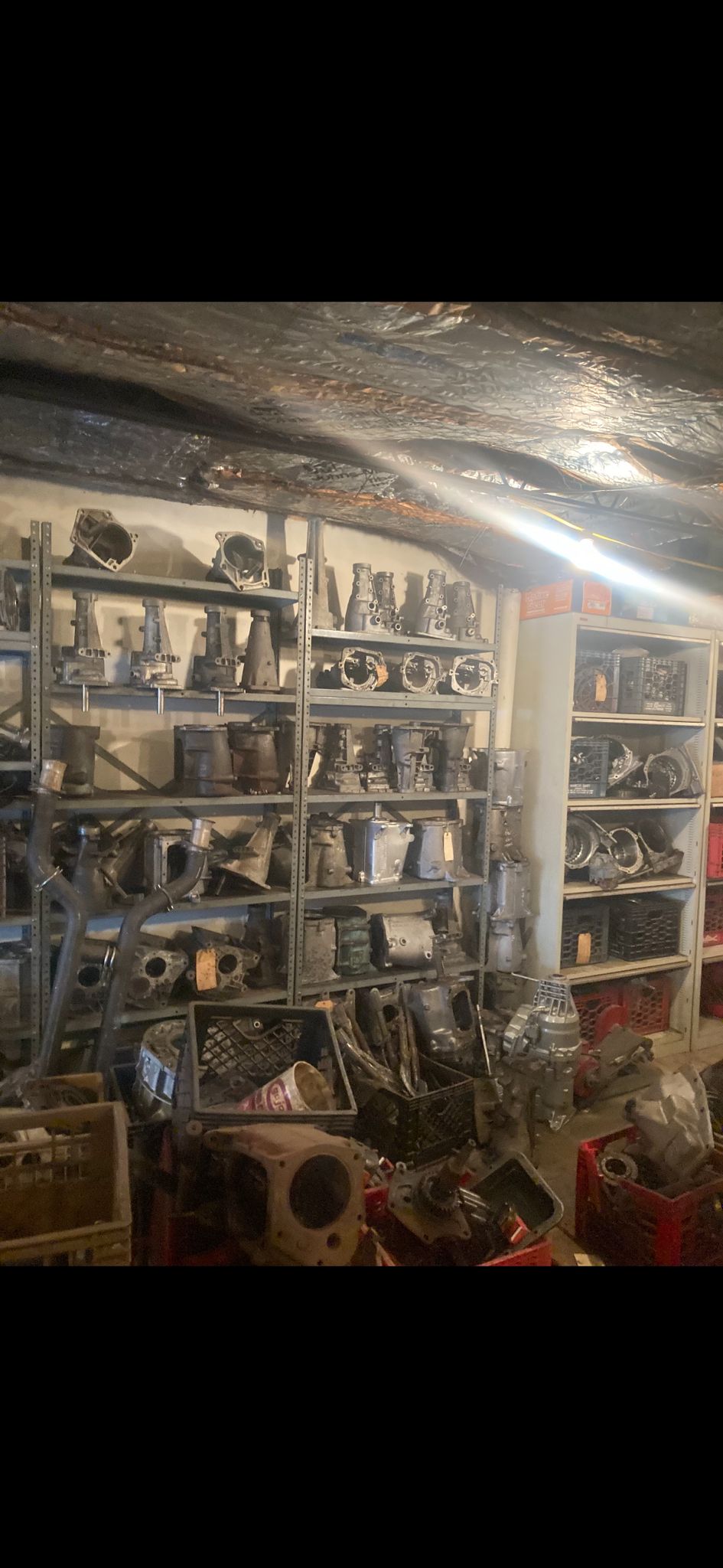Parts room with transmission cases and drivetrain components on shelves